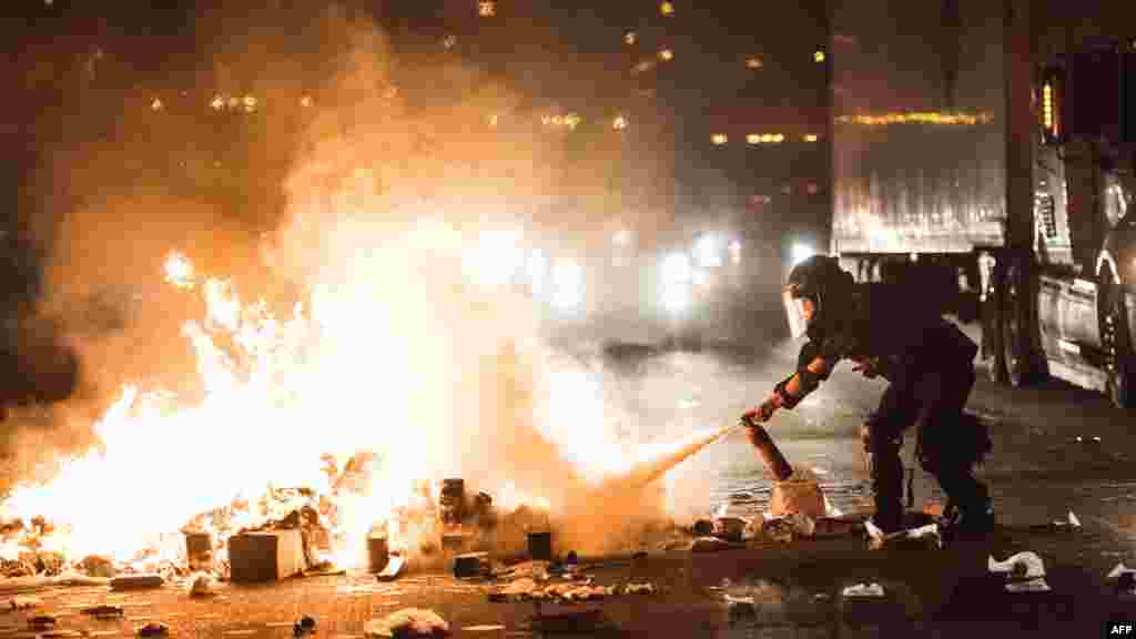 Un agent de police tente d'éteindre le feu sur la I-85 lors de manifestations suite à la mort d'un noir abattu par un agent de police à Charlotte, le 21 septembre 2016.