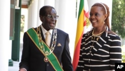 FILE: Zimbabwe President Robert Mugabe stands with his wife Grace, as they pose for a photo at State House in Harare, Oct, 28, 2014. 