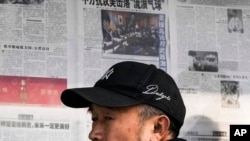 2023年2月6日，北京一男子閱讀報刊有關中國間諜氣球被美軍擊落的新聞報導後離開報亭。