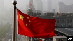 Bendera nasional China berkibar di gedung perkantoran di Shanghai, China, sebagai ilustrasi. Seorang utusan terkemuka China akan memulai lawatan ke Ukraina, Rusia dan negara-negara Eropa lainnya pada Senin (15/5). (Foto: AP)