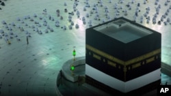 Muslimanski hodočasnici mole se izpred Ćabe, kockaste građevine u Velikoj džamiji, dok nose maske, na početku godišnjeg hodočašća hadž u Meki, Saudijska Arabija, 18. jula 2021.