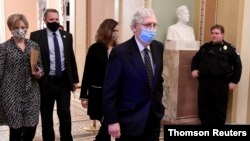Mitch McConnell, presidente de la mayoría republicana en el Senado regresa a la sala del pleno horas después del asalto de los partidarios del presidente Donald Trump al Capitolio, el miércoles 6 de enero de 2021.