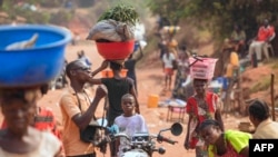 Vendeurs et passants se promènent dans une rue du quartier 3Z, à Tshikapa, en République démocratique du Congo, le 28 juillet 2017.
