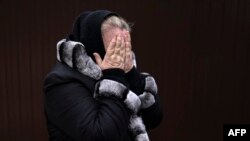 Tetiana Ustymenko, residente de Bucha, llora sobre la tumba de su hijo, enterrado en el jardín de su casa, en Bucha, al noroeste de Kiev, el 6 de abril de 2022, durante la invasión de Rusia a Ucrania.