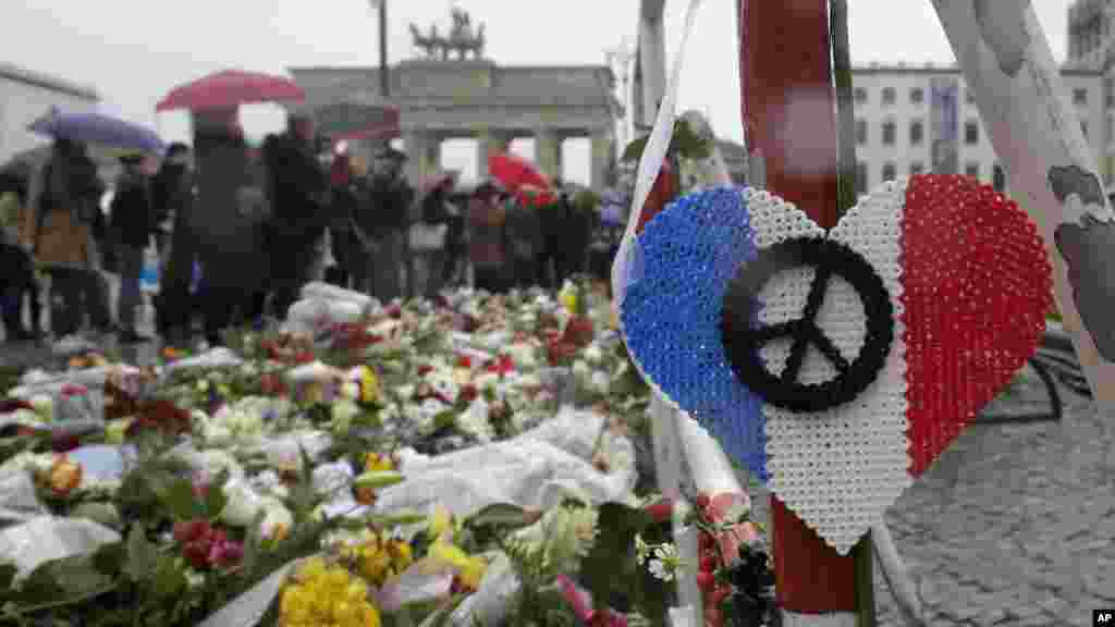 Tari Tarin Filawoyi Da Kyandura Da Jama'a Suka Tara A Kofar Ofishin Jakandancin Faransa Dake Berlin Kasar Jamus, Domin Jajantawa Wadanda Harin Da Aka Kai Ranar Juma'a Ya Rutsa Da Su, Nuwamba 15, 2015. 