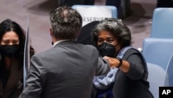 Ukraine's United Nations Ambassador Sergiy Kyslytsya, center, fist-bumps U.S. Ambassador Linda Thomas-Greenfield, left, after a Security Council meeting at U.N. headquarters, Jan. 31, 2022. (AP Photo/Richard Drew)