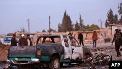 Destroyed vehicles are seen following a car bomb attack at a local market in the Turkish-held Syrian Kurdish town of Tel Hal along the border with Turkey in the northeastern Hassakeh province, Nov. 26, 2019.