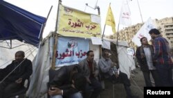 Para pengunjuk rasa penentang Presiden Morsi beristirahat di depan tenda yang diberi nama 'Partai Revolusi' di Lapangan Tahrir, Kairo (17/12). 