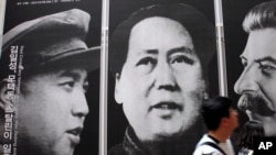 资料照片：在首尔一家韩战展览馆，游人走过战时三名共产党领袖金日成、毛泽东和斯大林的像。
