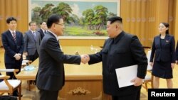 문재인 한국 대통령의 대북특별사절단 수석특사인 정의용 청와대 국가안보실장이 5일 김정은 북한 국무위원장과 악수하고 있다. 