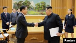 문재인 한국 대통령의 대북특별사절단 수석특사인 정의용 청와대 국가안보실장이 5일 김정은 북한 국무위원장과 악수하고 있다. 