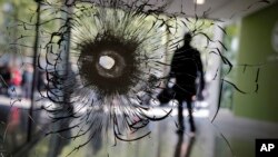 Lubang peluru nampak membekas di jendela sebuah toko di Champs Elysees boulevard, Paris, 21 April 2017. (AP Photo/Christophe Ena)