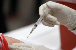FILE - A patient receives a flu vaccination in Mesquite, Texas, January 23, 2020.