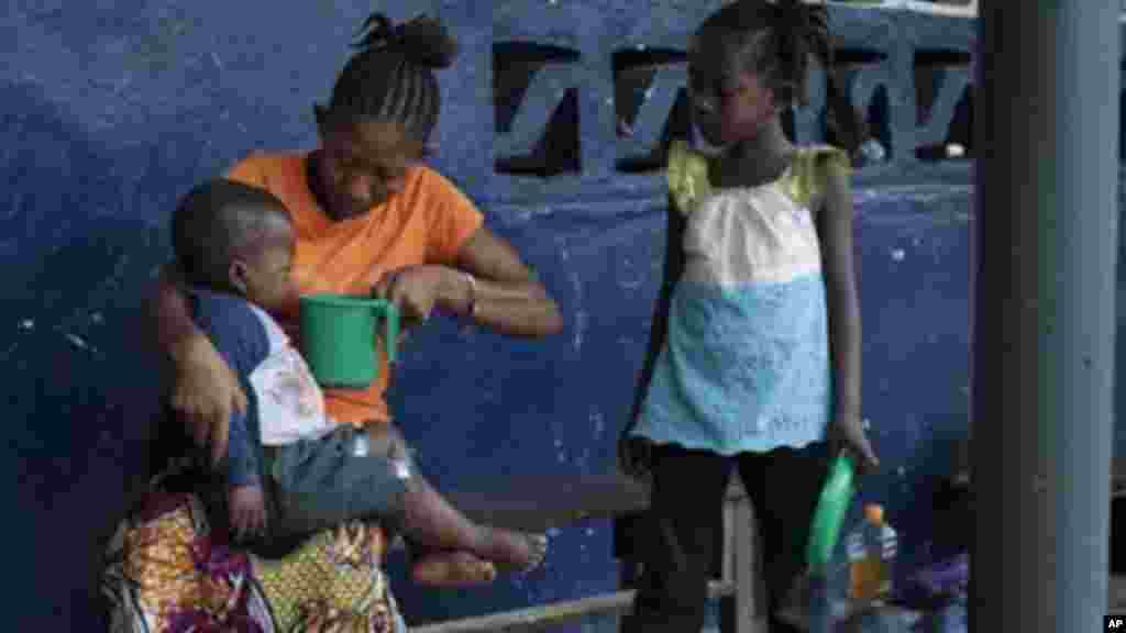 Marie Nyan, 26 ans, dont la mère est morte du virus Ebola, donne de l'eau à son fils de 2 ans Nathaniel Edward car ils attendent d'être pris par une ambulance après avoir montré des signes d'infection à virus Ebola dans le village de Freeman Réserve, à environ 30 miles au nord de Monrovia, Libéria.