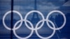 The Eiffel Tower is seen through a net with a part of the logo of the Paris 2024 Olympic and Paralympic Games from the Trocadero square in Paris