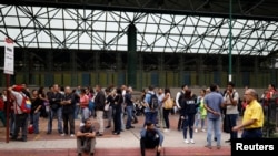 People wait for transportation outside a closed metro station during a blackout in Caracas, Venezuela, July 22, 2019. 