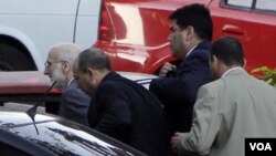 Alan Gross (extrema izquierda) cuando era llevado a juicio por agentes de la seguridad cubana en marzo pasado, en La Habana.