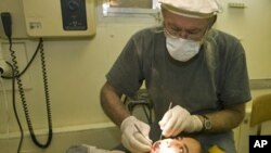 Likitan hakora Dr. James Rolfe, yana duba hakoran wani saurayi a kasar Afghanistan