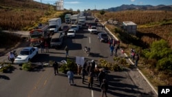 Manifestantes bloquean la carretera principal para protestar contra la violencia en Santa Catarina Ixtahuacan, Guatemala, el lunes 20 de diciembre de 2021.
