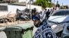 Los autos destruidos en un ataque con cohetes supuestamente disparados desde la Franja de Gaza se ven a través de una ventana dañada de una casa en la aldea de Arara, en el desierto de Negev, el 14 de octubre de 2023.