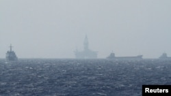 FILE - Ships and an oil rig, center, which China calls Haiyang Shiyou 981, and Vietnam refers to as Hai Duong 981, is seen in the South China Sea, off the shore of Vietnam, May 14, 2014.