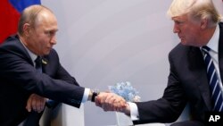Le président Donald Trump serre la main du président russe Vladimir Poutine lors du sommet du G20, à Hambourg, 7 juillet 2017.