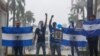 Archivo - Manifestantes sostienen banderas nacionales nicaragüenses y fotos de estudiantes asesinados, durante una marcha antigubernamental denominada "Nada es normal" en honor a Matt Romero, en Managua, Nicaragua, el 21 de septiembre de 2019. 