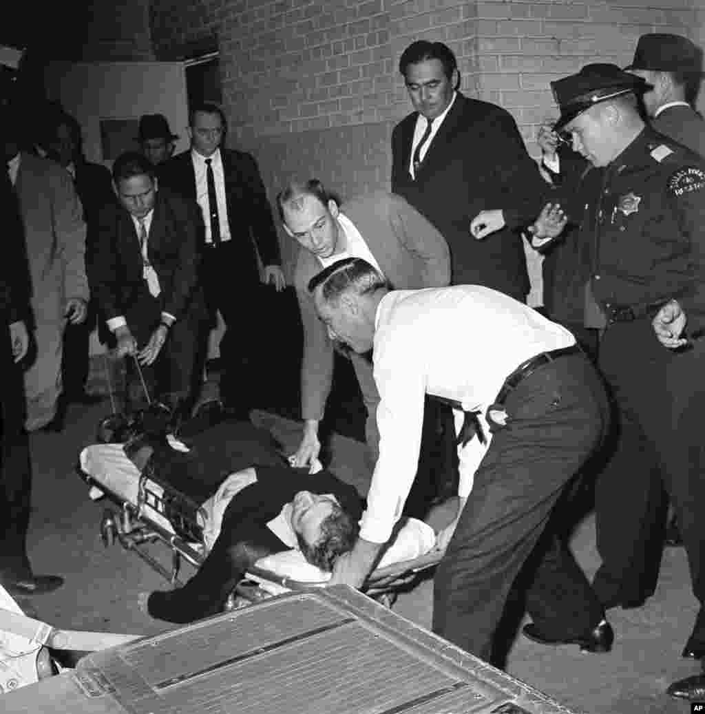 Lee Harvey Oswald, acusado del asesinato de John F. Kennedy, es colocado en una camilla después de recibir un tiro en el estómago cuando era trasladado.
