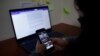 FILE - Xenia Oliva, an investigative reporter who had her phone hacked several times, including having data extracted, checks her phone at the office of GatoEncerrado in San Salvador, El Salvador, Jan. 11, 2022. 
