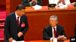El presidente chino, Xi Jinping (izq.), habla con el expresidente Hu Jintao después de dar un discurso durante la ceremonia de apertura del 20° Congreso Nacional del gobernante Partido Comunista de China en el Gran Palacio del Pueblo en Beijing, China, el 16 de octubre de 2019.