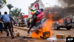 Un partisan du musicien ougandais devenu politicien Robert Kyagulanyi, également connu sous le nom de Bobi Wine, porte son affiche lors d'une manifestation contre l'arrestation de Kyagulanyi, lors de son rassemblement de campagne à Kampala, en Ouganda, le 18 novembre 2020.