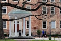 FILE - People remove belongings on campus at the University of North Carolina in Chapel Hill, N.C., March 18, 2020.