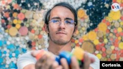 El artista venezolano Oscar Olivares muestra parte de los elementos con los que realiza sus murales, hechos a partir de tapas de botellas y por los que ha sido reconocido dentro y fuera de su país. [Foto: Cortesía del entrevistado]