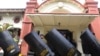 Police carry riot shields in front of a court building in Surabaya, East Java, Indonesia, Jan, 16, 2023, ahead of a trial of five defendants accused of negligence in last October's deadly crowd surge at a soccer match. 