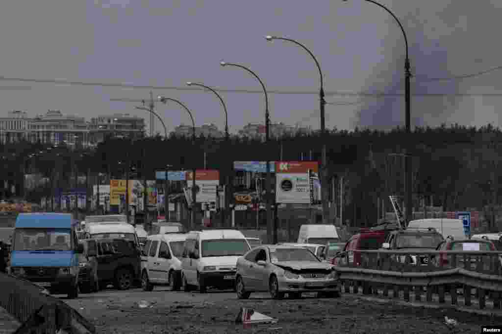 Abandoned cars are seen on a road as local residents evacuate from the town of Irpin after days of heavy shelling by Russian troops, March 7, 2022.