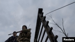 A service member of the Ukrainian armed forces stands by the only escape route used by locals to evacuate from the town of Irpin, after days of heavy shelling, while Russian troops advance towards the capital, March 7, 2022.