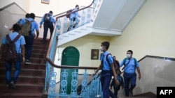Niños caminan a sus respectivas aulas después de que las escuelas reanudaron las clases físicas que se cerraron antes para frenar la propagación del coronavirus en Calcuta, la India, el 3 de febrero de 2022.