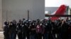 Deportados guatemaltecos se reúnen frente a un centro de migración del gobierno después de llegar en un vuelo de deportación desde los EE. UU., en la sede de la Fuerza Aérea de Guatemala (FAG) en el aeropuerto internacional La Aurora, Guatemala, el 28 de diciembre de 2021.