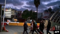 Ciudadanos ucranianos caminan junto con activistas en el lado mexicano de la frontera después de que las autoridades de Aduanas y Protección Fronteriza les negaron el ingreso a los Estados Unidos bajo el Título 42, en el puerto de cruce de San Ysidro, el 9 de marzo 2022.