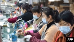 中国安徽省阜阳市临泉县的工人在制造扬声器的生产线上工作。（2022年3月31日）