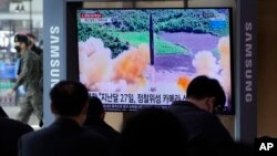  FILE - People watch a TV showing a file image of North Korea's missile launch during a news program at the Seoul Railway Station in Seoul, South Korea, March 5, 2022. 
