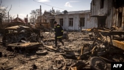 Un pompier marche dans les décombres de la ville de Trostianets, dans le nord-est de l'Ukraine, le 29 mars 2022.
