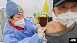 中國山東省青州的醫護人員在給一名男子接種新冠疫苗。（2022年12月29日）
