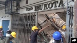 Trabajadores inspeccionan una tienda dañada durante un sismo en Cianjur, Java Occidental Indonesia, el lunes 21 de noviembre de 2022. (AP Foto/Firman Taqur)