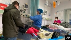 ARCHIVO - Los pacientes yacen en sus camas en el Hospital Central en la ciudad de Zhuozhou, en la provincia de Hebei, en el norte de China, el miércoles 21 de diciembre de 2022.