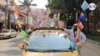 Bajad Alala, como se hace llamar este colombiano de 57 años en época de Mundial, posa junto a su taxi en una de las calles de Medellín. [Foto: Federico Buelvas]