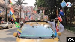 Bajad Alala, como se hace llamar este colombiano de 57 años en época de Mundial, posa junto a su taxi en una de las calles de Medellín. [Foto: Federico Buelvas]