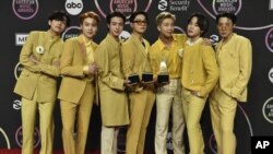 BTS posa en la sala de prensa con los premios al dúo o grupo pop favorito, canción pop favorita por "Butter" y artista del año en los American Music Awards el domingo 21 de noviembre de 2021 en el Teatro Microsoft de Los Ángeles. (Foto de Jordan Strauss/Invision/AP)