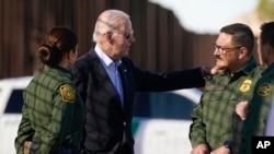 ARCHIVO - El presidente Joe Biden habla con agentes de la Patrulla Fronteriza de EE. UU. en un tramo de la frontera entre EE. UU. y México en El Paso, Texas, el 8 de enero de 2023. 