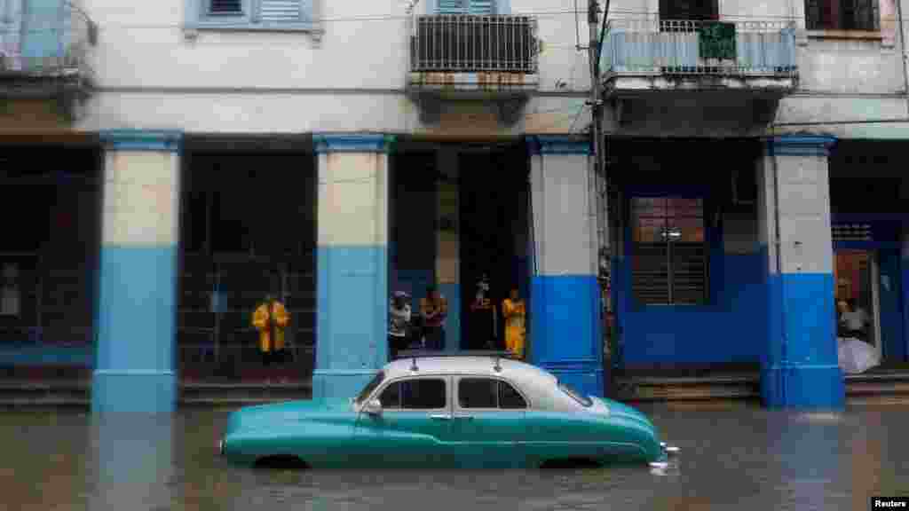 Un automóvil antiguo queda varado en medio de la corriente de agua provocada por las fuertes lluvias el 3 de junio en Cuba.
